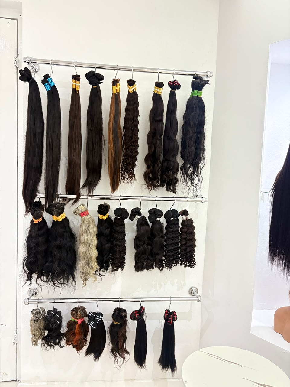 A wall of Silque Luxe hair bundles and wefts in every texture and shade