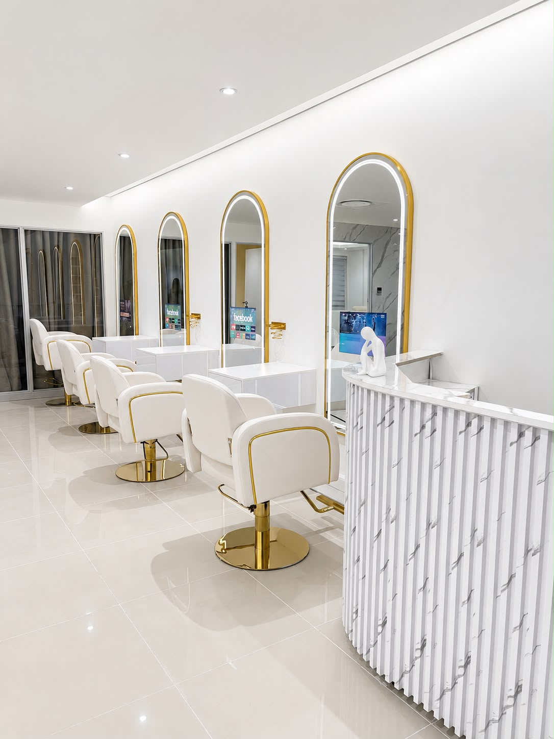 Inside Silque Luxe — arched gold mirrors, white styling chairs and marble reception
